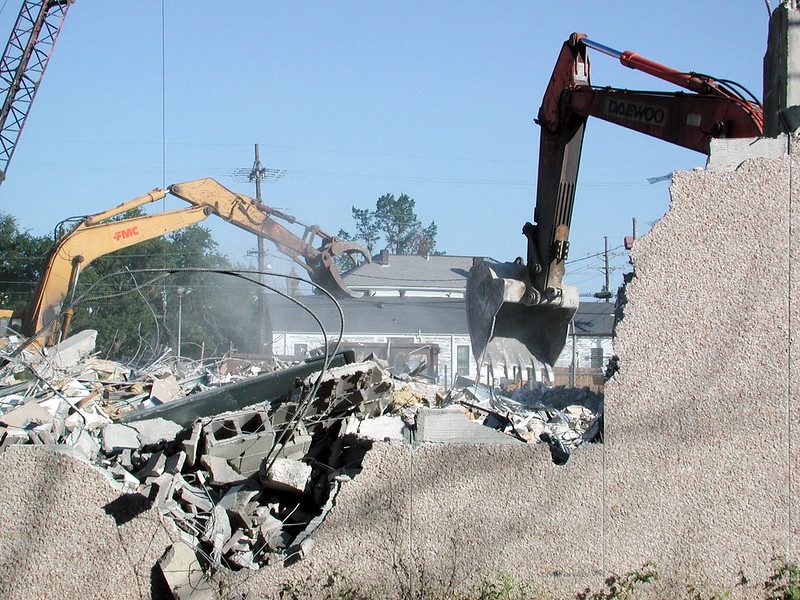 image of building being torn down by construction equipment